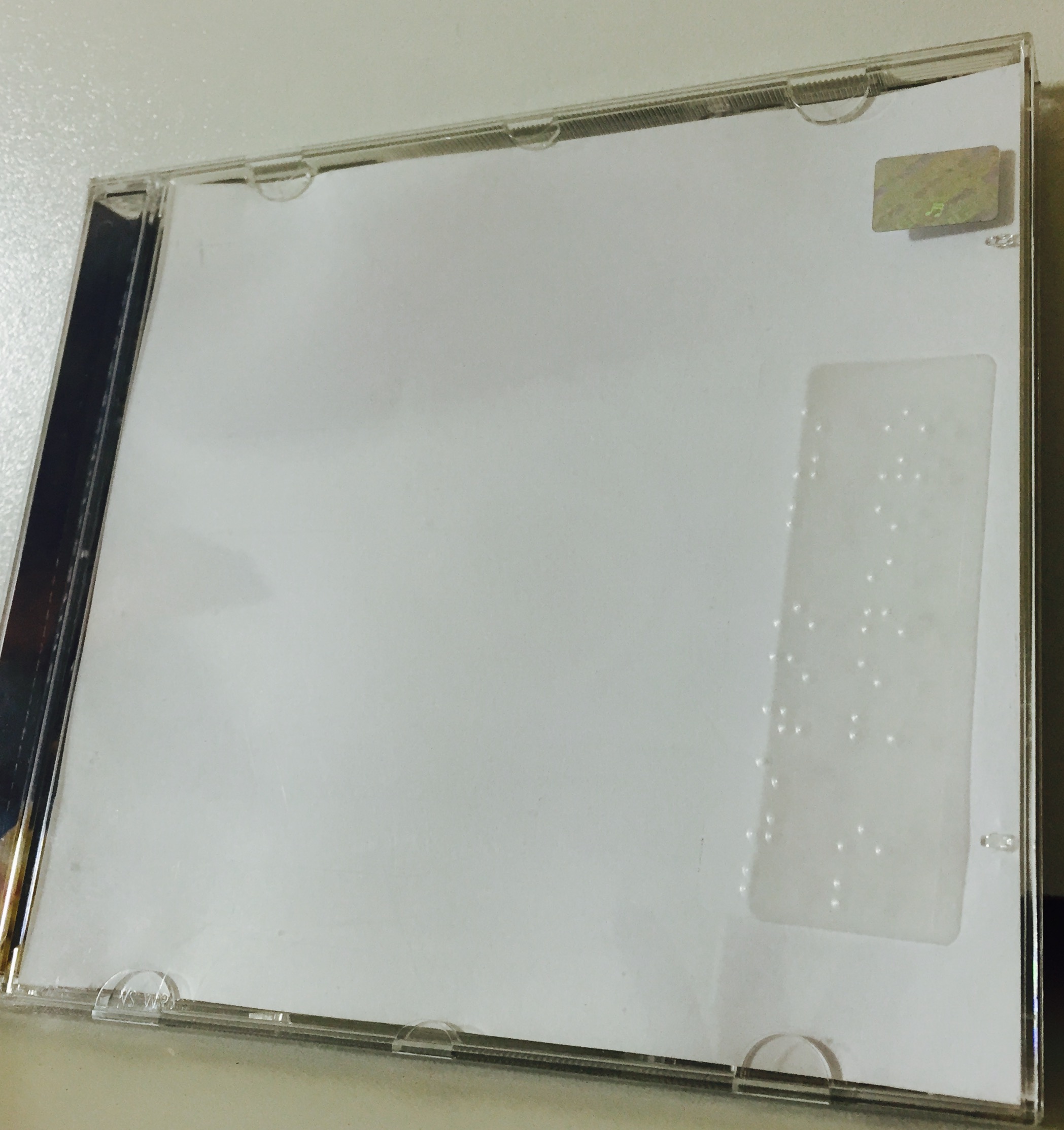 foto da caixa de um cd com uma etiqueta transparente em Braille
